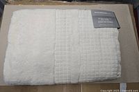 Folded ivory bath towel showing waffle border