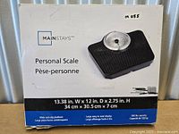 Front of boxed Mainstays personal scale showing product image and branding
