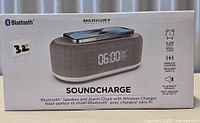 Front of retail box showing SoundCharge Bluetooth speaker alarm clock with wireless charger, model image and features