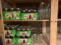 Cartons of Ball canning jars and loose jars on shelves