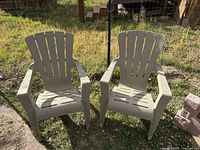 Pair of beige plastic Cape Cod style chairs on grass