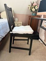 Side profile of black/brown stained pine chair with white cushion