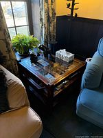 Square dark wood coffee table with glass top and lower shelf