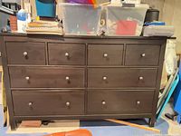 Front view of dark brown 8-drawer dresser with items on top