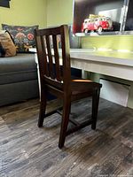 rear angled view of dark stained solid wood kids chair
