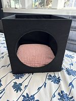 Front view of black cube cat cubbyhole with pink cushion inside