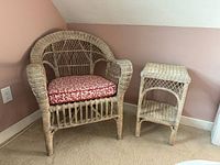 Wicker chair with cushion beside wicker side table