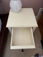 Side table with drawer extended, shows interior and top surface