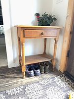 front view of solid oak side table showing drawer, turned legs, lower shelf