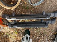 Top view of two Yakima black rooftop ski-snowboard carriers laying on ground