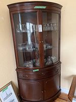 full view of corner cabinet showing glass upper section and wood lower section