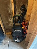 Full view of Simoniz pressure washer standing upright with cords and hose