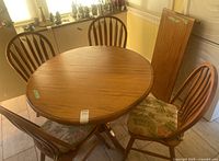 Round wooden table surrounded by four matching chairs