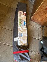 Full view of carry bag with product panel and red strap