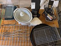 Overhead view of all items: coffee maker, Dutch oven, Pyrex dishes, metal pans and racks