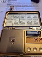 Scale showing charm weight 0.52 g with charm visible