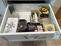 Drawer view showing all four appliances, cords, cups and booklet