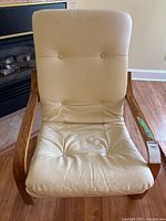 Full front view of wooden chair with cream leather cushion