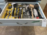 Drawer with flatware, utensils and visible mallet