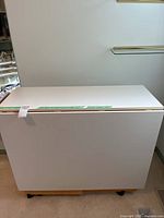 Full view of closed cutting table on casters