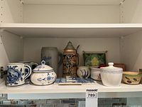 Shelf with entire assortment of Delft pieces, steins, bowls, tiles