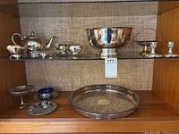 Overall view of silver-plated serveware on two shelves