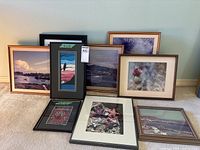 Group view of seven framed items leaning against wall