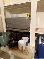 shelf with assorted ceramic pots, grey planter, spray bottle, grow bags