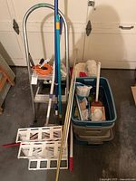 Overall lot showing ladder, bins, cords, cleaning tools