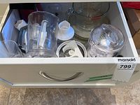 Drawer view showing multiple chopper parts, Pyrex measuring cup and processor components