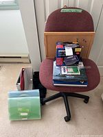 Front of chair with cork board, books, file accessories displayed
