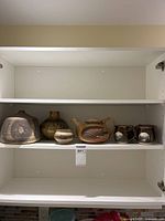 Cabinet shelf with all seven pottery pieces displayed