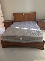 Full view of assembled queen bed with mattress, headboard, rails