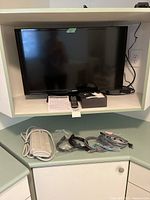 Overall view of Samsung TV, Apple TV box, remote, surge protector and cables