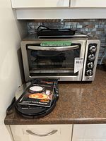 Front view of both appliances: KitchenAid toaster oven, Chef’sChoice waffle maker