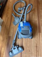 Full view of vacuum with hose, wand, carpet head and floor attachment