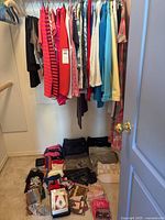 Overview of hanging clothes and accessories on closet floor