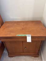 Front and top view of wooden nightstand showing double doors and drawer