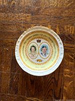 Front view of commemorative plate showing portraits, inscription and trim