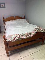 Overall view of assembled double size wooden bed frame with mattress showing headboard, footboard, side rails