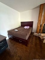 Full view of bed frame showing headboard, mattress present, two storage drawers visible