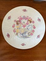 Front view showing Victorian couple, floral design, gold rim