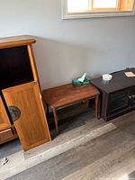 Front view of the wooden side table between larger cabinets