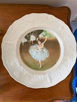 Front view showing Degas ballerina image and embossed rim