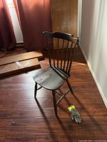 Full view of dark wood spindle-back chair on hardwood floor