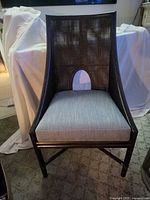 Front view of wood chair showing cane back, oval cutout and upholstered seat