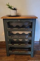 Front view of green solid wood wine rack with natural wood top