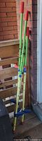 Both sets of adjustable kids’ stilts leaning against wall
