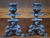 Front view of both ornate metal candlestick holders