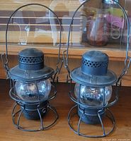 Two matching vintage metal railroad lanterns side by side